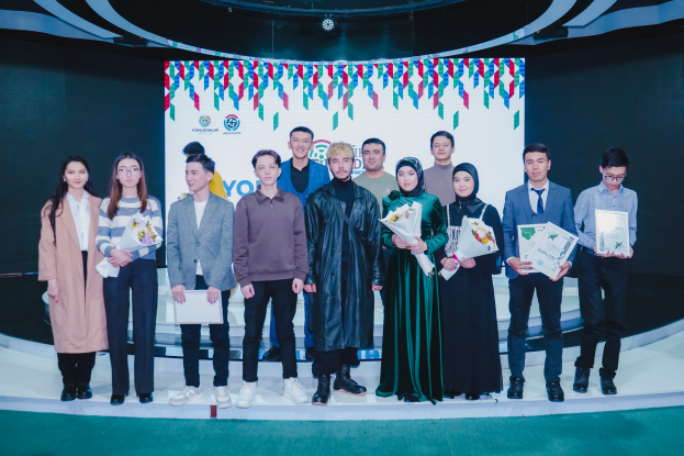 Eine Gruppe von Menschen auf einer Bühne, jeder hält einen Blumenstrauß und Urkunden in den Händen, im Hintergrund eine Tafel mit der Aufschrift "Youth Solar Awards 2019".