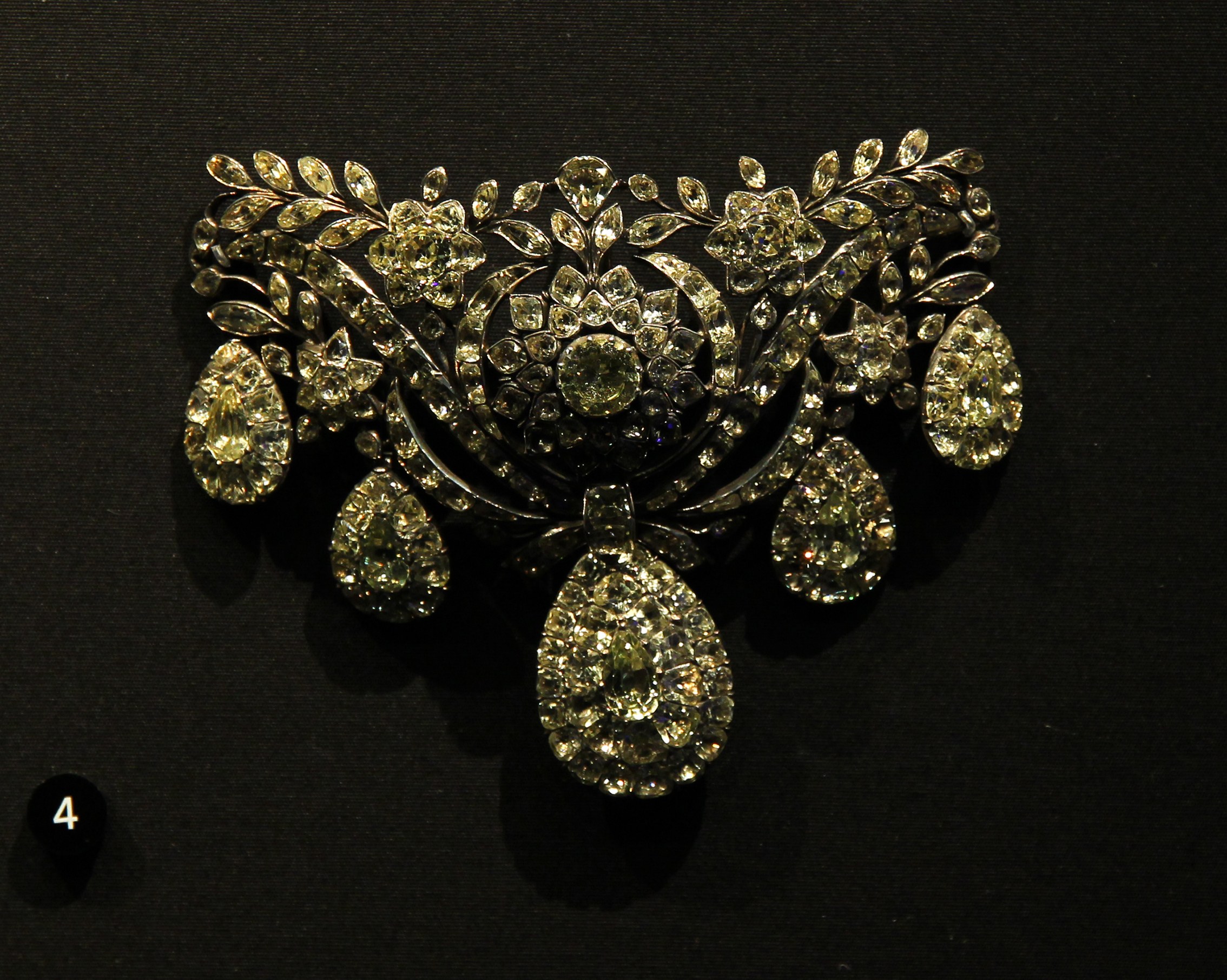 Eine goldene und diamantene Brosche in einem Museum ausgestellt, verziert mit funkelnden Diamanten.