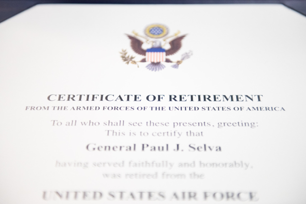 Rahmenurkunde der United States Air Force mit blauer Einfassung, die ein zentrales Sternschild-Logo zeigt, umgeben von einem Lorbeerkranz und einer 'Retirement'-Bannerschrift in Schwarz.