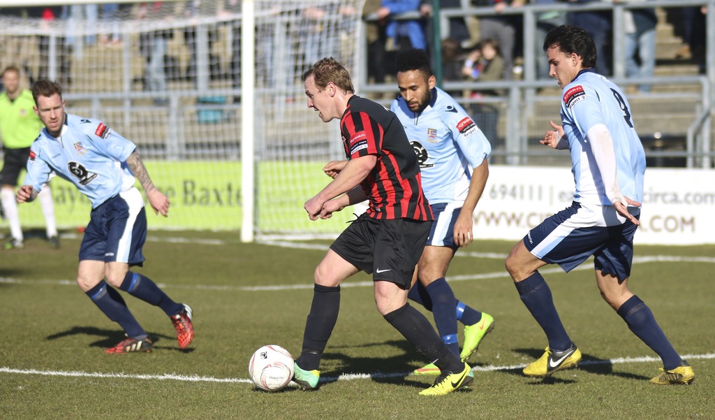 Eine Gruppe von Menschen beim Fußballspielen auf einem Feld.