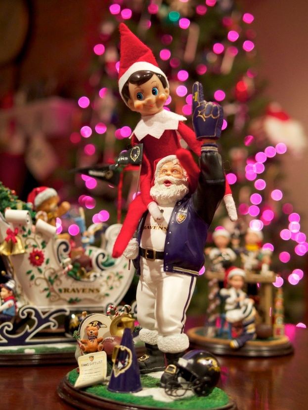 Spielfiguren im Vordergrund mit einem Weihnachtsbaum mit Lichtern im Hintergrund.
