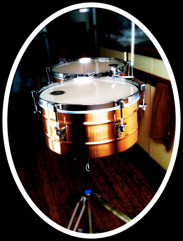 Eine Sammlung von Musikinstrumenten, darunter eine Gitarre, ein Saxophon und ein Schlagzeug, die auf einem h├Âlzernen Boden angeordnet sind.
