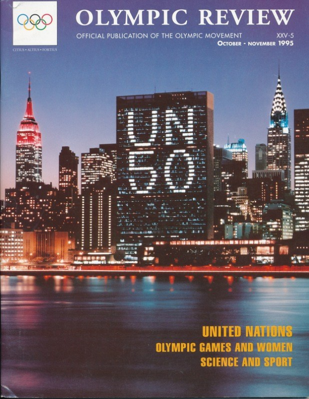 Buch mit dem Titel "Olympic Review Official Publication of the Olympic Movement" mit einer Stadtansicht auf dem Cover, das auf einer flachen Oberfläche liegt.