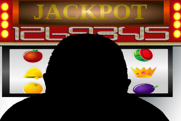 Ein Mann spielt ein Online-Spielautomaten-Spiel mit "Jackpot" angezeigt, umgeben von fruchtmotivischen Bildern und Text auf dem Bildschirm.