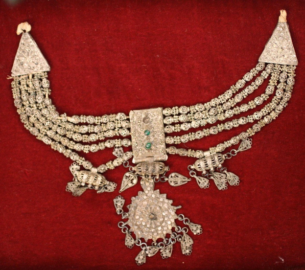 Silberschmuck mit Smaragden und Diamanten auf rotem Samt.