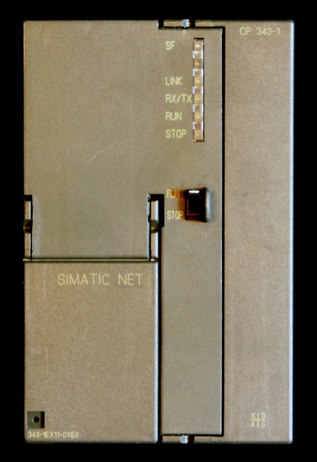 Nahaufnahme eines SIMATIC NET-Geräts auf schwarzem Hintergrund mit Text und elektronischen Bauteilen.