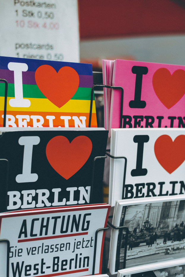 Ein Gestell mit verschiedenen Büchern und Postern mit der Aufschrift "Ich liebe Berlin", vor einem unscharfen Hintergrund.