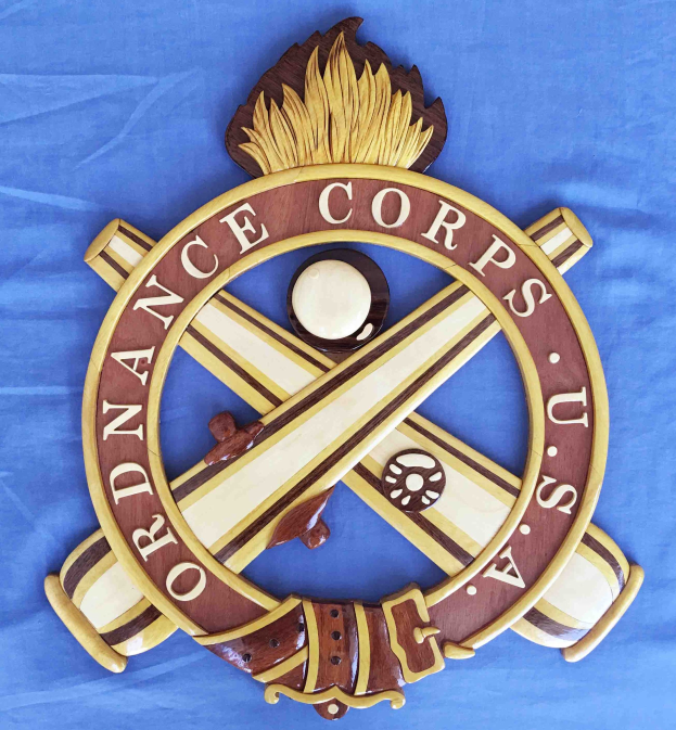 Holzschild mit "Ordnance Corps"-Text, zeigt ein geschnitztes weißes Stern auf blauem Hintergrund mit goldener Umrandung, angebracht an blauem Stoff.