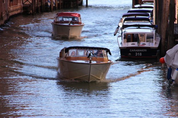 Mehrere Boote schwimmen auf dem Wasser, mit Grenzen links und rechts im Bild.