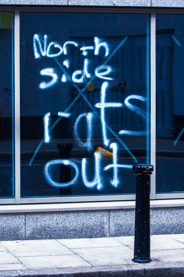 Text auf einem Fenster und eine Absperrstange auf der Straße.