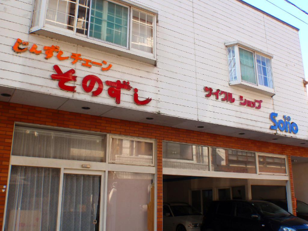 Ein Schaufenster mit Fenstern und zwei Autos davor geparkt.