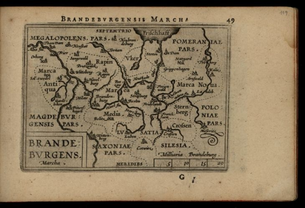 Altes Buch mit einer detaillierten Karte der Brandenburg-Region Deutschlands auf schwarzem Hintergrund, begleitet von Texten über die Region.