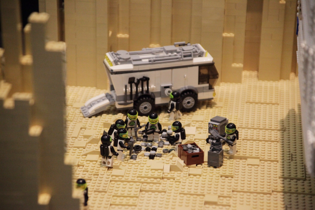 Lego-Modell einer Star-Wars-Szene mit einem Fahrzeug im Vordergrund und einer Wand im Hintergrund.